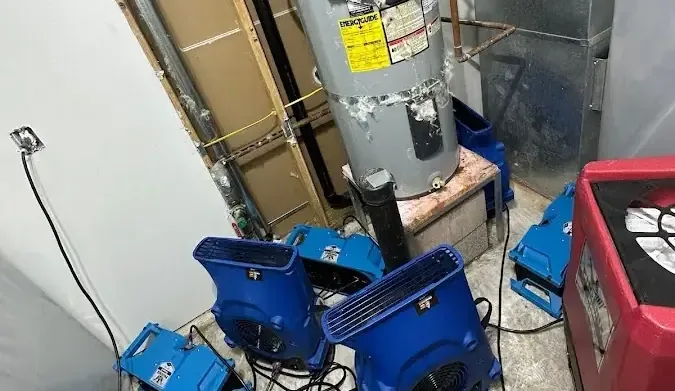 Air movers and a dehumidifier beside a water heater closet